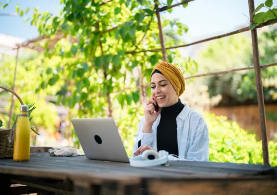 Frau beim Online-Seminar des TourismusHub in einem Garten