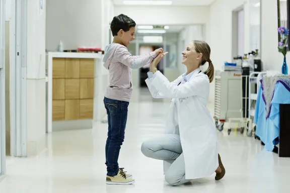 Doctor giving high-five to boy in corridor